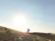 a couple in sand dunes at sunset